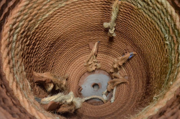 The inside of an Anduze Urn with the wood frame removed and the rope remaining